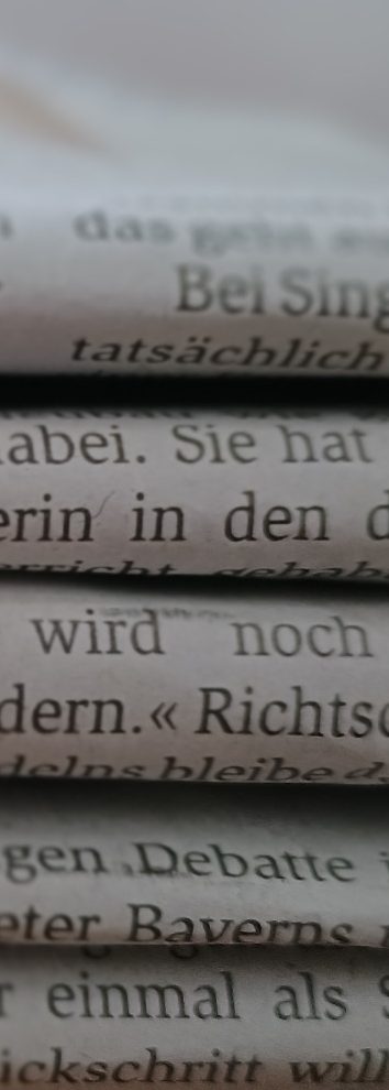 Detailaufnahme von mehreren Zeitungsrücken, die aufeinander liegen