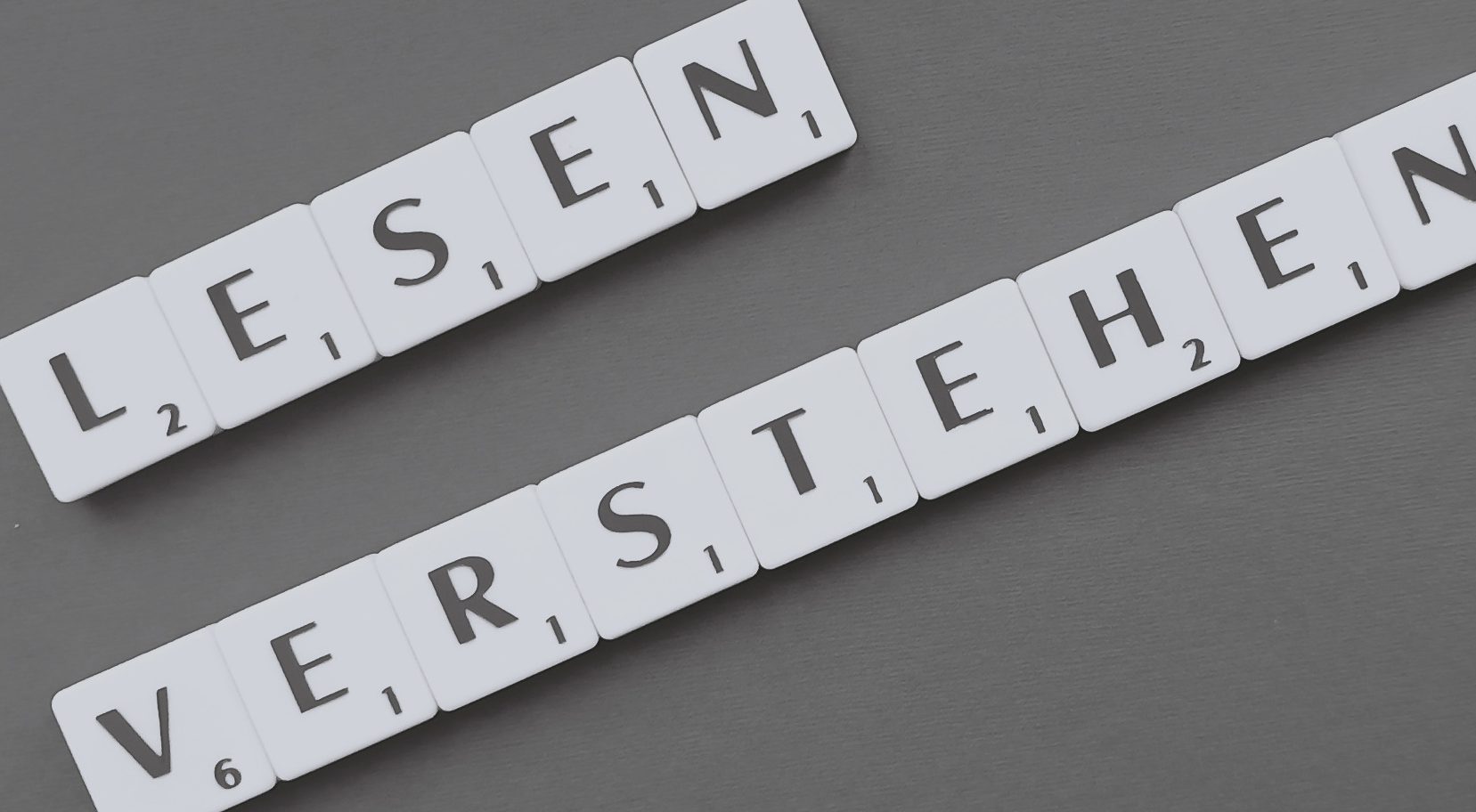 Mit Buchstabensteinen sind die Worte "lesen" und "verstehen" gelegt